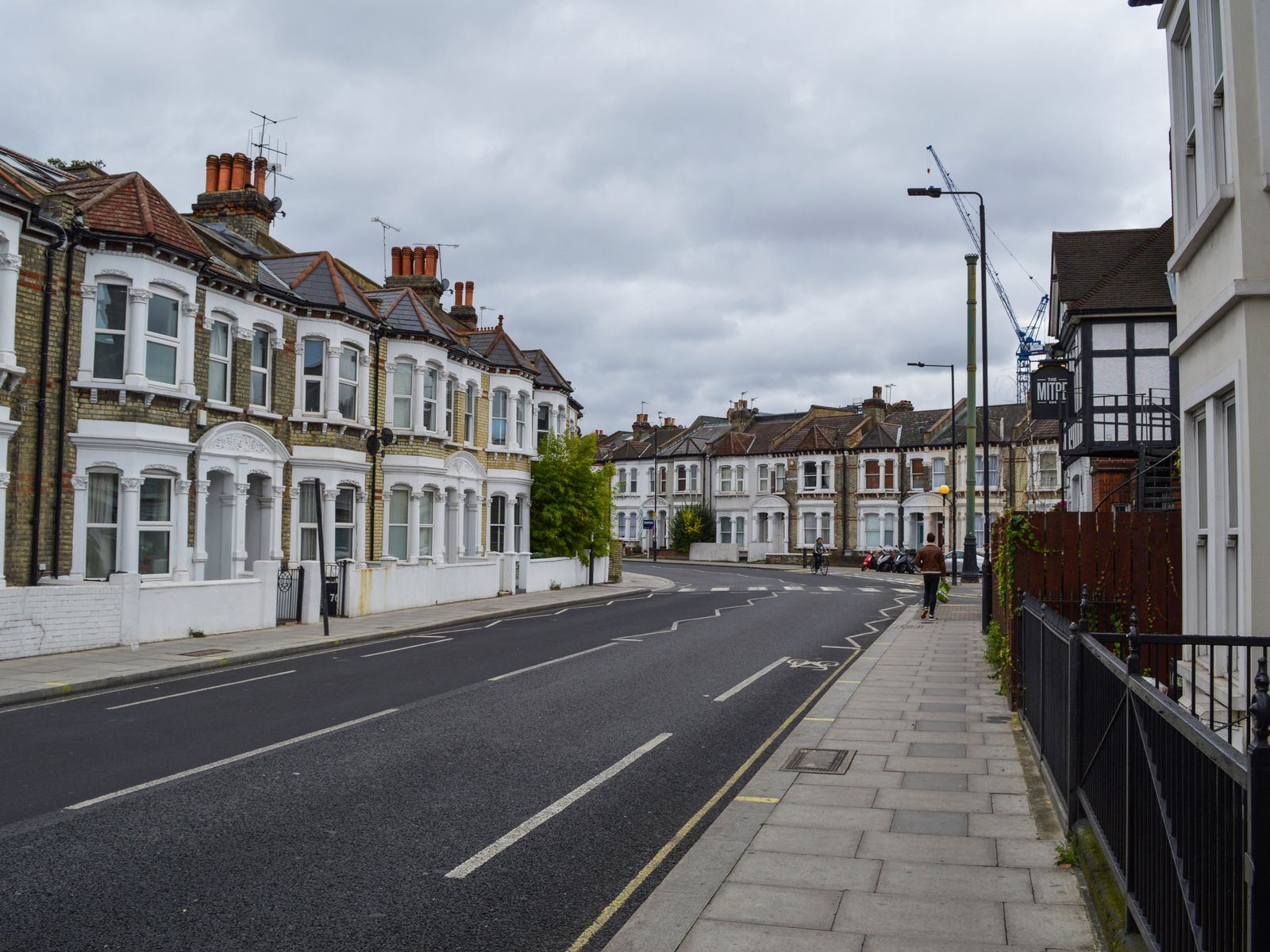 A row of Victorian terraced houses with bay windows along a quiet street.
